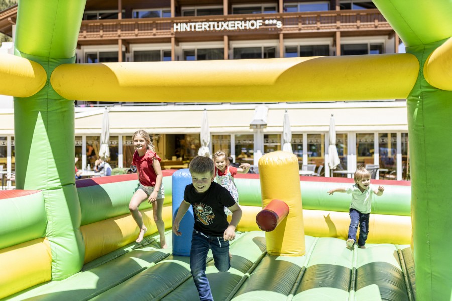 Lachende Kinder in der Hüpfburg vor dem Hotel Hintertuxerhof