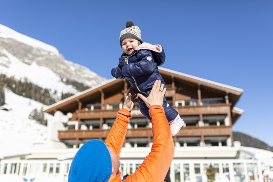 Vater mit Baby vor dem Hotel Hintertuxerhof im Winter