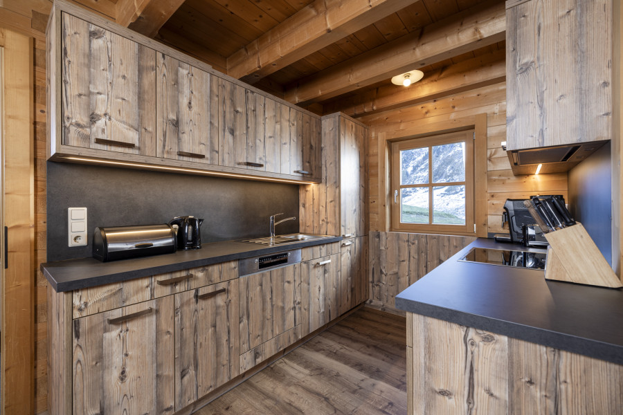 Offene Wohnküche im Erdgeschoss der Family Lodge Maximilian mit Holzelementen und moderner Ausstattung.