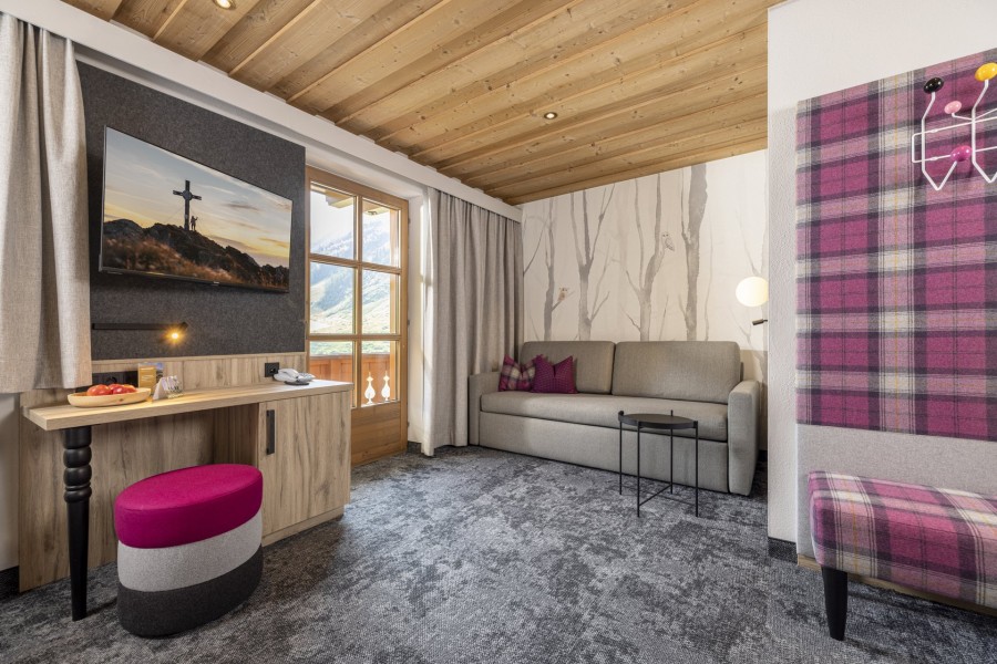 Familiensuite 5 Tirol, gemütliche Couchecke mit TV, die Couch ist mit Schlaffunktion ausgestattet