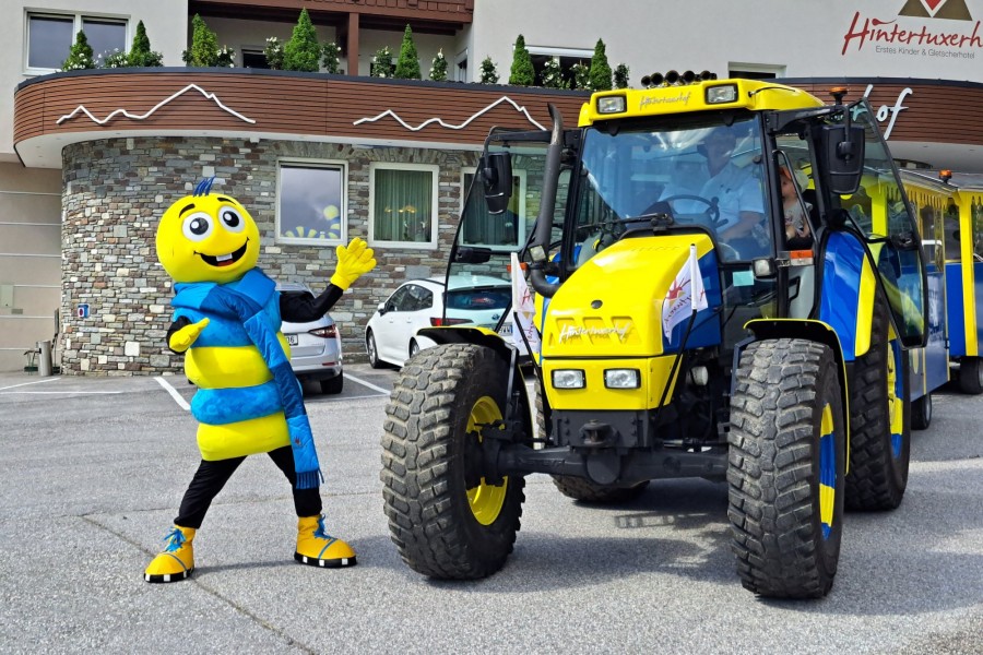 Maskottchen Kurt der Gletscherwurm posiert neben dem Panoramazug vor dem Hintertuxerhof.