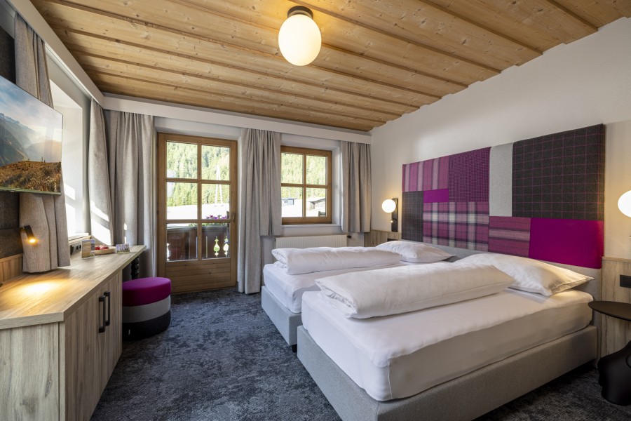 Komplettansicht des Schlafzimmers der Juniorsuite Tirol mit modernen Details und hellem Design.