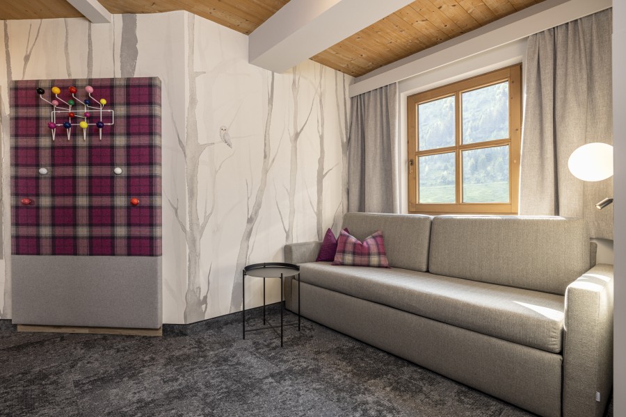 Eleganter Sitzbereich der Juniorsuite Tirol mit Tisch und modernen Designelementen. 