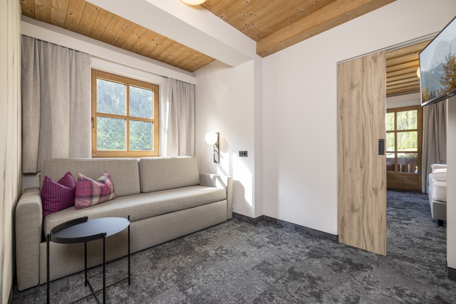 Eleganter Sitzbereich der Juniorsuite Tirol mit Tisch und modernen Designelementen.