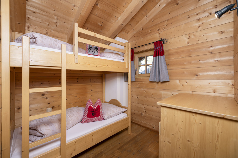Kinderzimmer im Obergeschoss der Family Lodge Maximilian mit einem Hochbett aus Holz.