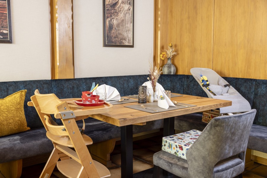 Gedeckter Tisch im Restaurant Hintertuxerhof mit Kinderausstattung wie Kinderstuhl, Sitzkissen usw