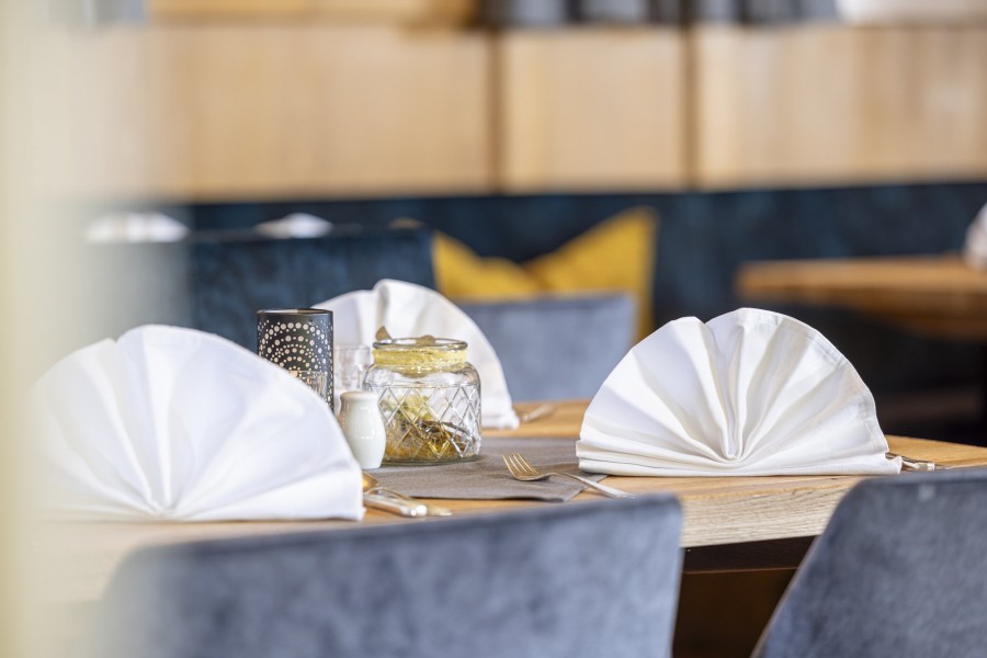 Detailaufnahme eines gedeckten Tisches. Kunstvoll gefaltete Servietten und Tischdekoration im Restaurant des Hintertuxerhofs.