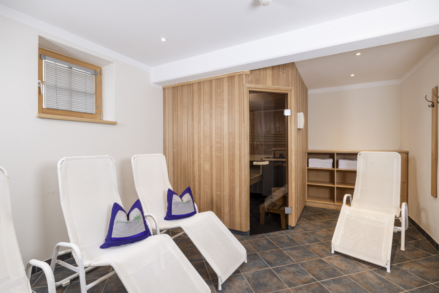 Ruhebereich im Untergeschoss der Family Lodge Maximilian mit Liegestühlen neben der Sauna.