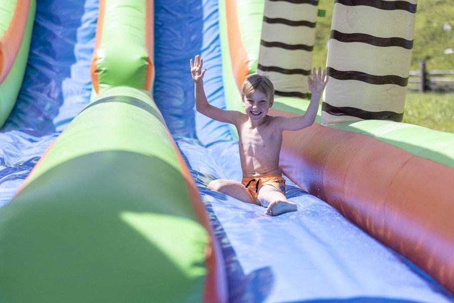 Kind auf der bunten Wasserrutsche im Spielbereich des Hintertuxerhofs.