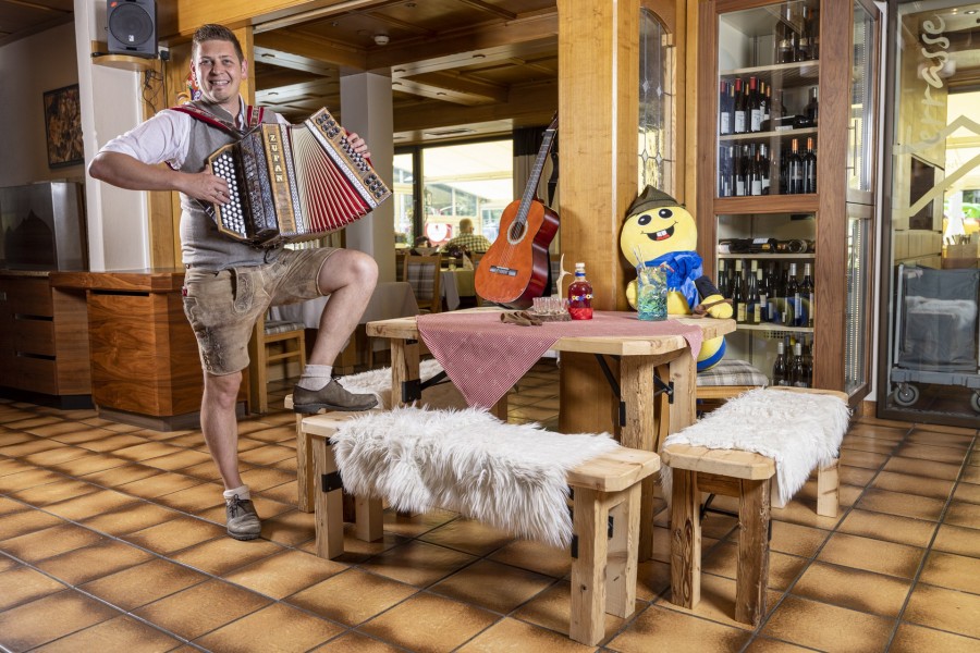 Gastgeber Christian Kofler mit Ziehharmonika im Restaurant